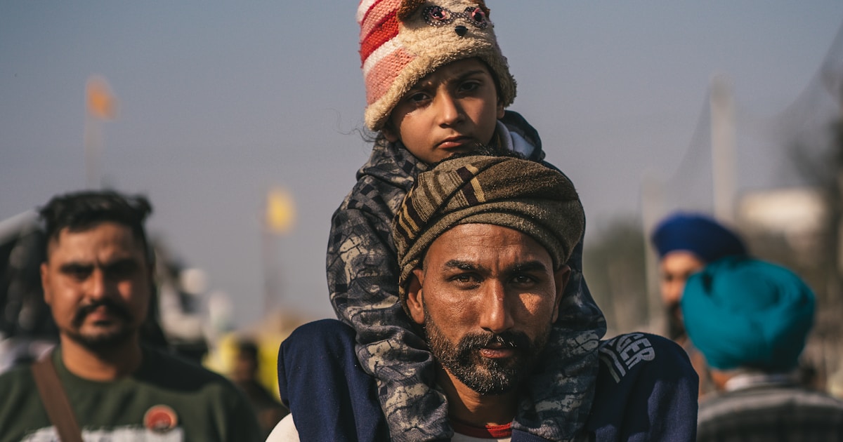 Family at a border checkpoint with documents and luggage during conflict