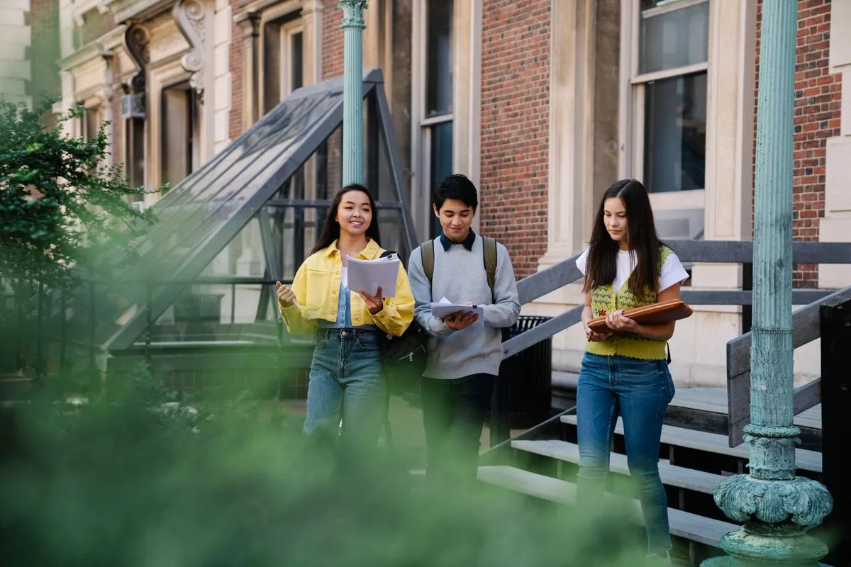 Students walking and talking outside a university building.